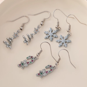 Christmas earrings set featuring silver trees, snowflakes and candy canes in a ceramic dish