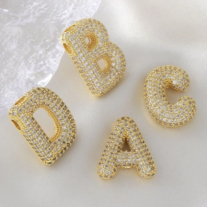 Detail of 18k gold plated alphabet charms with white cubic zirconia pavé for DIY jewelry