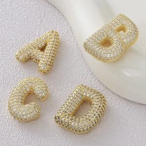 Macro view of 18k gold plated A-D letter pendants with micro-pave cubic zirconia