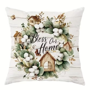 Floral cushion cover with Bless Our Home text and botanical prints on white wood background