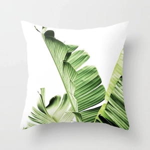 Close-up of green banana leaf pattern on a square peach skin fabric pillow cover