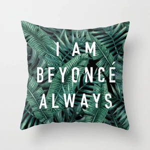Close-up of square peach skin pillowcase with tropical leaves and Beyoncé text design