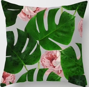 Detail of tropical monstera leaves and pink roses printed on a square pillow cover