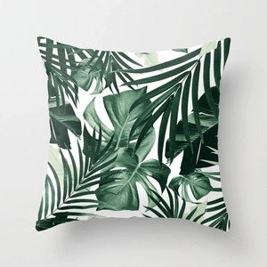 Close-up of tropical monstera leaf patterns on white peach skin fabric cushion
