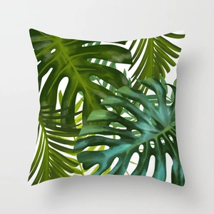 Close-up of tropical monstera leaf prints on square peach skin cushion cover fabric