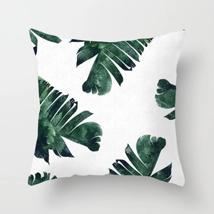 Macro detail of the Nordic style pillowcase featuring green tropical leaf print on white