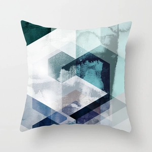 Macro view of geometric patterns and teal watercolor texture on a square pillow case
