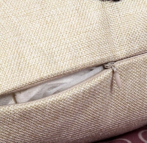Detailed close-up of a hidden zipper on a textured linen Halloween skull cushion cover