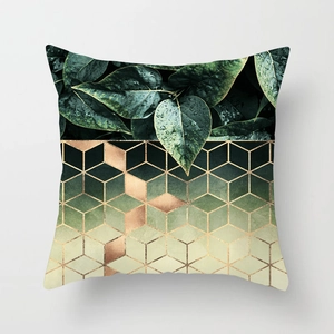 Detail of square pillowcase with green leaf photography and gold geometric cube patterns