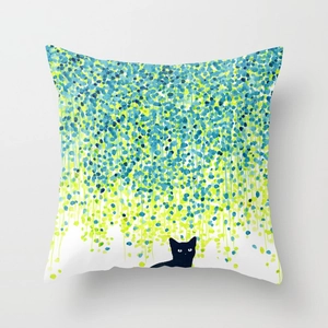 Close-up of peach skin cushion cover featuring green botanical prints and a black cat silhouette