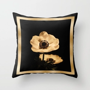 Detailed view of anemone floral print and golden border on black square pillowcase