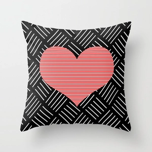 Close-up of geometric heart pillowcase with red heart motif and black white stripes