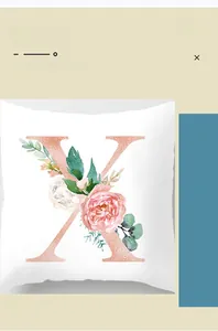 Detail of white square cushion cover featuring a floral letter X in rose gold print