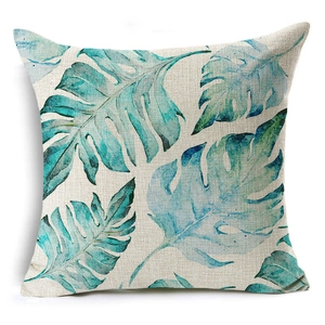 Close-up of linen cushion cover featuring watercolor tropical leaves and woven texture