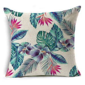 Detail of linen pillowcase with vibrant tropical hibiscus flowers and palm leaf prints