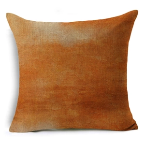 Detailed close-up showing the coarse linen fabric texture and orange artistic print on pillow cover