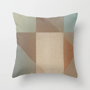 Close-up of modern geometric patchwork cushion cover with linen texture and earth tones