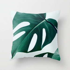 Macro detail of tropical monstera leaf print on a square peach skin decorative throw pillow