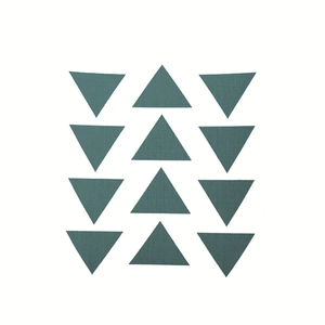Detailed view of dark green triangle geometric patterns on a linen pillowcase