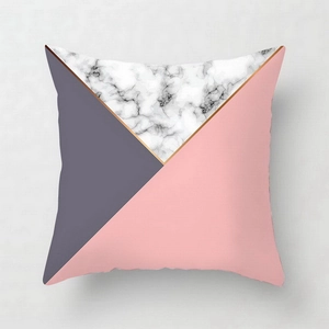 Close-up of geometric pink marble pillow cover with golden lines and grey texture