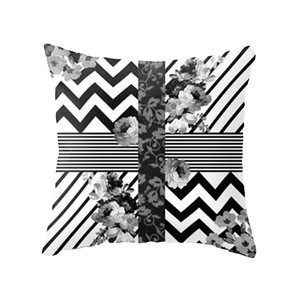 Detailed view of square pillow cover with black and white geometric patterns and floral motifs