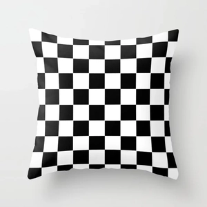 Close-up of square cushion cover with black and white checkered pattern and smooth texture