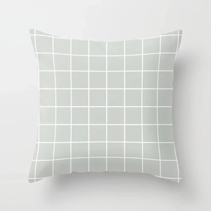 Detail of grey-green linen pillow cover featuring white grid pattern and fine stitching