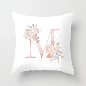Detail of soft peach skin cushion cover with rose gold letter M and pink floral pattern