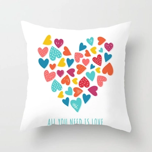 Detail view of heart print cushion cover with All You Need Is Love text on peach skin fabric