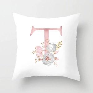 Detailed macro view of watercolor letter T and pink floral patterns on peach skin pillowcase