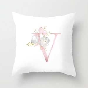 Close-up of peach skin pillowcase with rose gold floral letter V in modern style