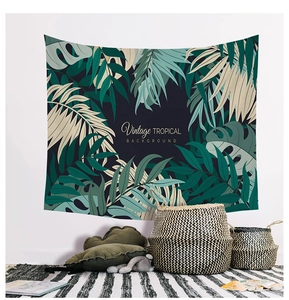 Detail view of a Nordic style tapestry with tropical monstera leaves on a white wall