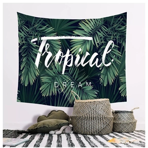Detail of tropical palm leaf tapestry with Tropical Dream text in a cozy home setting