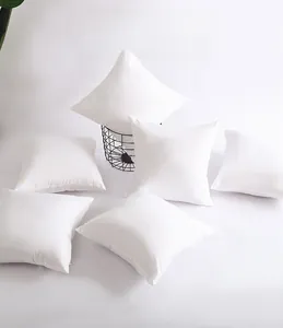 Stack of plain white square peach skin polyester pillowcases with smooth fabric texture