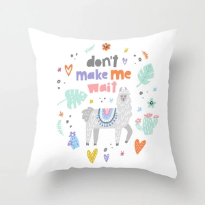 Detail of white square cushion cover featuring a colorful cartoon alpaca and desert motifs