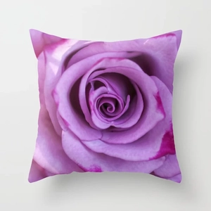 Macro detail of the soft fabric texture and purple rose print on the square pillow case
