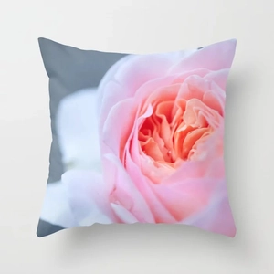 Close-up of pink rose print on square cushion cover with soft fabric texture details