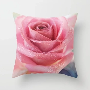 Macro detail of soft pillowcase featuring a pink rose print with realistic water droplets