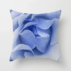 Macro detail of blue rose petals on a square decorative pillow cover with fine velvet texture