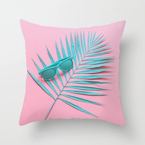 Detail view of pink tropical cushion cover featuring teal palm leaf and sunglasses print