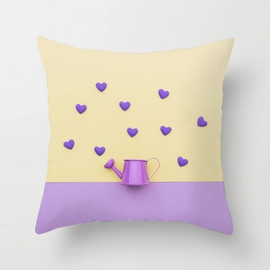 Detail of pink tropical leaves pillow case with heart pattern and purple watering can