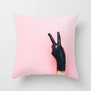 Detail of Nordic pink cushion cover featuring artistic black hand peace sign print