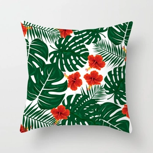 Detail of tropical peach skin pillowcase featuring green palm leaves and red hibiscus flowers