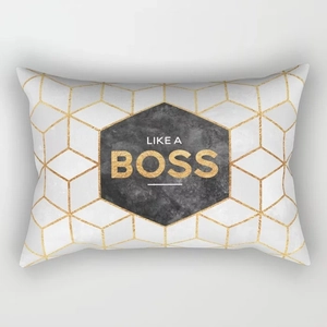 Nahaufnahme von geometrischem Kissenbezug mit goldenen Sechsecken und Like A Boss Druck