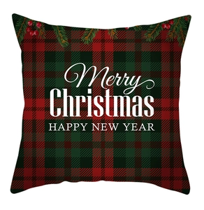 Detail of red and green tartan Christmas pillowcase with Merry Christmas text and pine branch