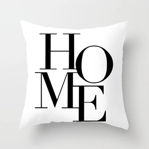 Detail of white square pillowcase with black HOME typography and woven fabric texture