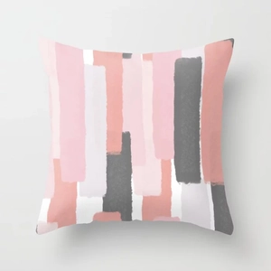 Détail de rayures géométriques rose et corail sur une housse de coussin de canapé