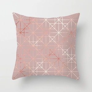 Detail of rose gold geometric lines on a soft pink peach skin fabric cushion cover