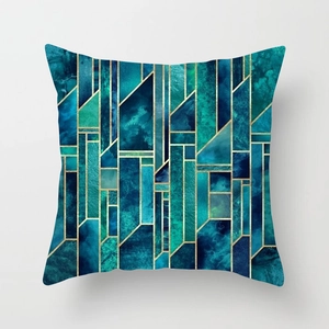 Detailed macro of geometric peach skin cushion cover with gold lines and teal marble texture