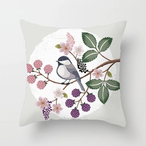 Detail of floral pillow cover featuring a bird and pink flowers on linen fabric